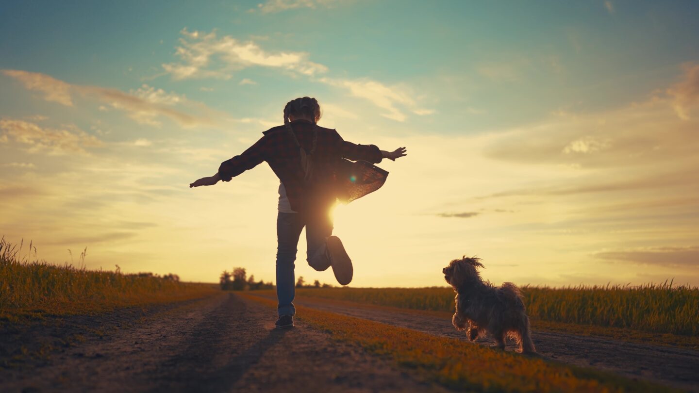girl running with her dog outside